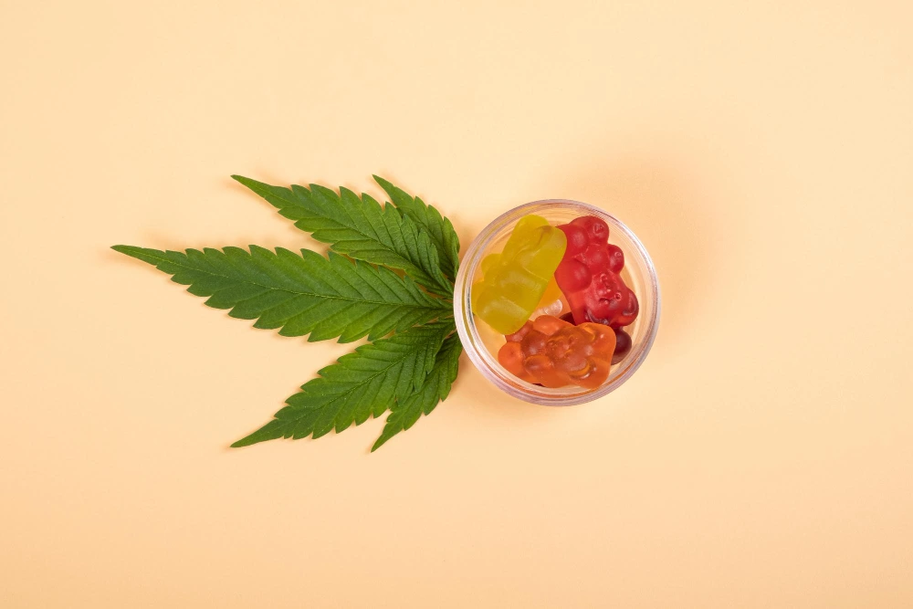 Thc jelly candies cannabis sweets drugs and green leaf on yellow background