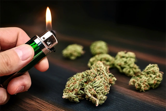 Image of a man holding a lighted joint